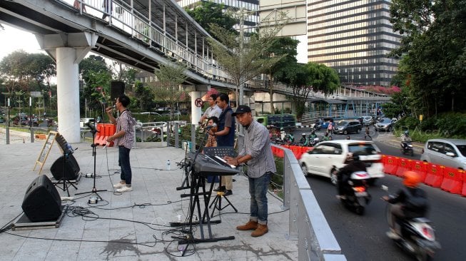 Sejumlah seniman tampil membawakan musik untuk menghibur warga yang melintas di area Taman Spot Budaya, Dukuh Atas, Jakarta, Jumat (12/7). [Suara.com/Arief Hermawan P]