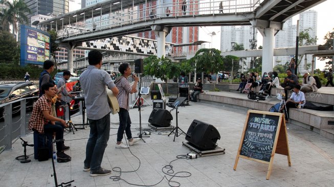 Sejumlah seniman tampil membawakan musik untuk menghibur warga yang melintas di area Taman Spot Budaya, Dukuh Atas, Jakarta, Jumat (12/7).[Suara.com/Arief Hermawan P]