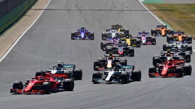 Pebalap Ferrari, Sebastian Vettel (kiri), memimpin balapan F1 GP Inggris selepas start di Sirkuit Silverstone, Minggu (8/7/2018). [AFP/Andrej Isakovic]