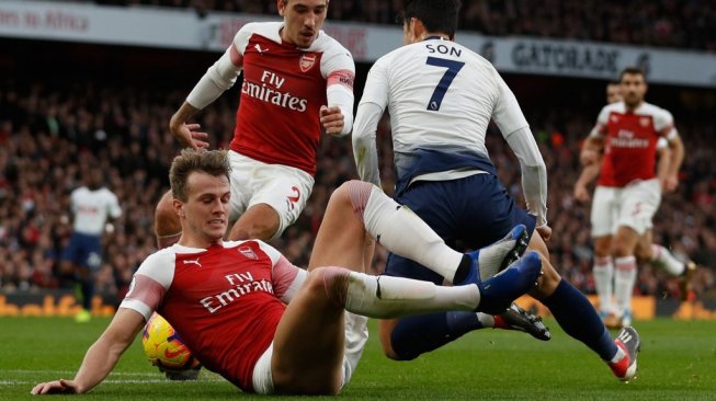 Bek Arsenal, Rob Holding (kiri) melanggar pemain Tottenham Hotspur, Son Heung-Min dalam lanjutan Liga Primer Inggris musim 2018/2019. (ADRIAN DENNIS / AFP)