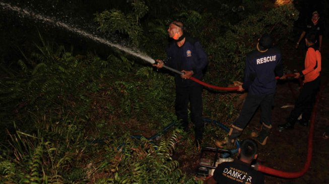 Petugas pemadam kebakaran berupaya memadamkan api yang membakar lahan gambut di Kawasan Desa Kuta Padang, Kecamatan Bubon, Aceh Barat, Sabtu (13/7). ANTARA FOTO/Syifa Yulinnas