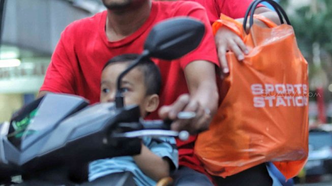 Warga membawa barang bawaan menggunakan tas plastik di Pasar Baru, Jakarta, Minggu (14/7). [Suara.com/Muhaimin A Untung]