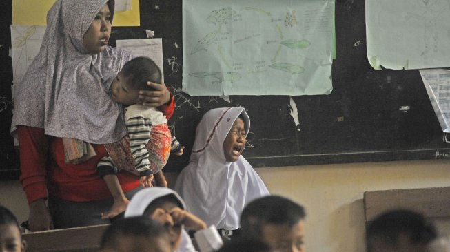 Seorang murid menangis karena ditinggalkan oleh orangtuanya di SD Negeri Sumber Agung Serang, Banten, Senin (15/7).[ANTARA FOTO/Asep Fathulrahman]
