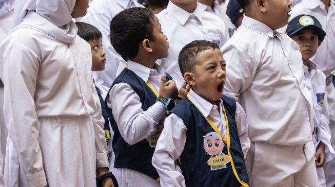 Seorang siswa menguap saat mengikuti upacara penyambuatan peserta didik baru pada hari pertama masuk sekolah di SD Muhammadiyah 5 Jakarta, Kebayoran Baru, Jakarta Selatan, Senin (15/7). [ANTARA FOTO/Aprillio Akbar]