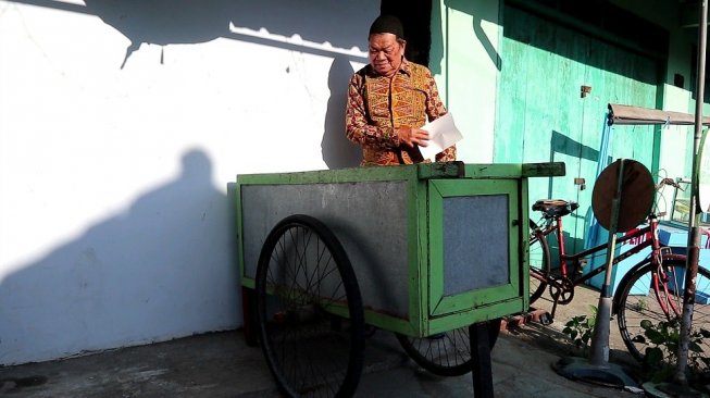 Samsuri membereskan gerobak buburnya.