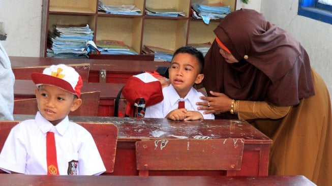 Orang tua menemani anaknya saat hari pertama masuk sekolah di Sekolah Dasar Negeri (SDN) Suak Timah, Samatiga, Aceh Barat, Aceh, Senin (15/7/2019). [FOTO/Syifa Yulinnas]