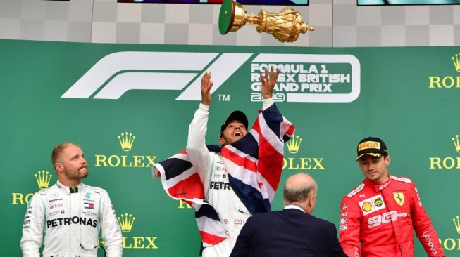 Pebalap Mercedes, Lewis Hamilton (kedua dari kiri), merayakan keberhasilannya menjuarai Formula 1 GP Inggris 2019 di Sirkuit Silverstone, Minggu (14/7). [AFP/Andrej Isakovic]