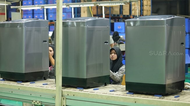 Pekerja melakukan proses pembuatan mesin cuci di Pabrik Mesin Cuci Sharp Indonesia, Karawang International Industrial City (KIIC), Jawa Barat, Selasa (16/7).[Suara.com/Muhaimin A Untung]