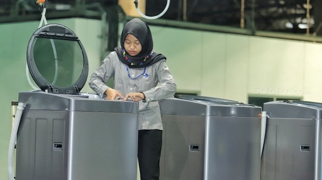 Pekerja melakukan proses pembuatan mesin cuci di Pabrik Mesin Cuci Sharp Indonesia, Karawang International Industrial City (KIIC), Jawa Barat, Selasa (16/7).[Suara.com/Muhaimin A Untung]