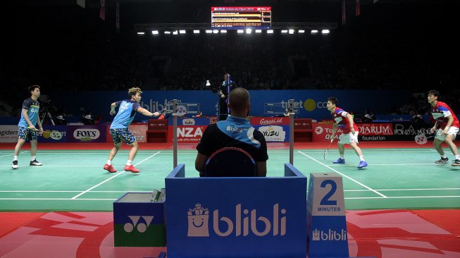 Pebulu tangkis ganda putra Indonesia Marcus Gideon dan Kevin Sanjaya saat bertanding melawan pebulu tangkis ganda putra Jepang Takuto Inoue dan Yuki Kaneko dalam babak pertama Blibli Indonesia Open 2019 di Istora Senayan, GBK, Jakarta, Selasa (16/7). [Suara.com/Arief Hermawan P]