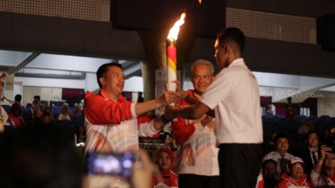 Menpora Imam Nahrawi (kiri) dan Gubernur Jateng Ganjar Pranowo (tengah) dalam acara pembukaan ASEAN School Games 2019 di Holly Stadium, Semarang, Jateng, Kamis (18/7) malam. [Suara.com/Adam Iyasa]