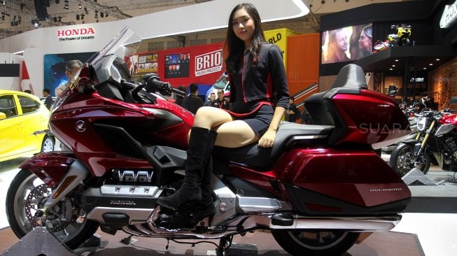 Sales Promotion Girl (SPG) berpose di depan kendaraan yang dipamerkan di GIIAS 2019, ICE BSD, Tangerang, Banten, Kamis (18/7). [Suara.com/Arief Hermawan P]
 