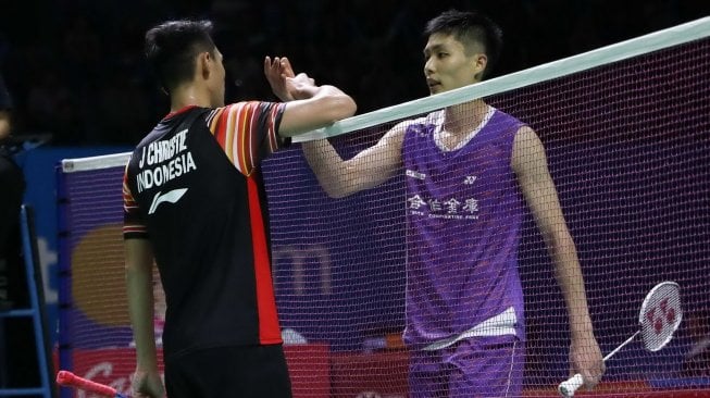 Pebulutangkis tunggal putra Indonesia, Jonatan Christie (kiri), bersalaman dengan Chou Tien Chen (China Taipei) usai tersingkir di babak perempat final Indonesia Open 2019 di Istora Senayan, Jakarta, Jumat (19/7). [Humas PBSI]