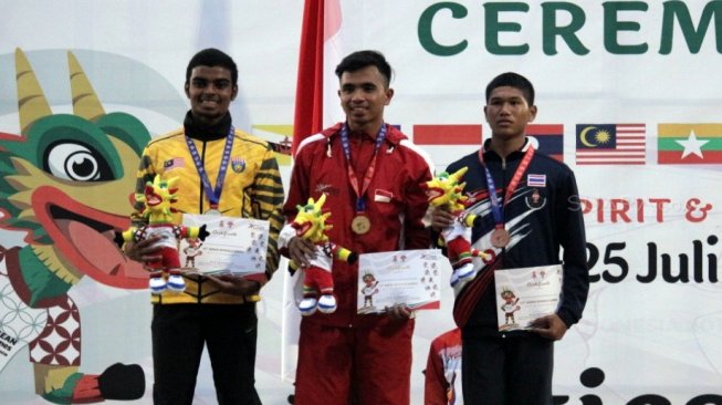 Atlet atletik Indonesia, Dewa Radika Syah (tengah) meraih medali emas di nomor lari 400 meter putra ASEAN School Games 2019 di GOR Tri Lomba Juang Semarang, Jumat (19/7). [Suara.com/Adam Iyasa]