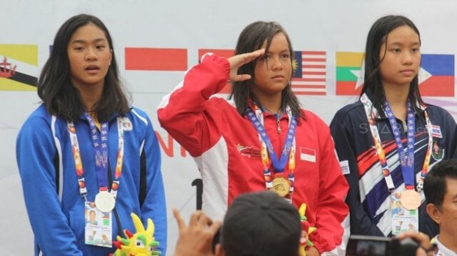 Perenang Adelia (tengah) menyumbang medali emas pertama bagi tim renang Indonesia di ASEAN School Games 2019 dari nomor nomor 50 meter gaya dada di Venue Renang Jatidiri, Semarang, Jawa Tengah, Jumat (19/7). [Suara.com/Adam Iyasa]