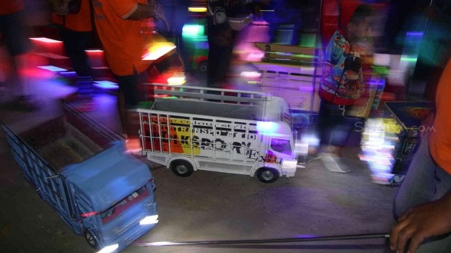 Peserta menarik miniatur truk berbahan baku kayu saat Festival Miniatur Truk di Kota Kediri, Jawa Timur, Sabtu (20/7) malam. ANTARA FOTO/Prasetia Fauzani