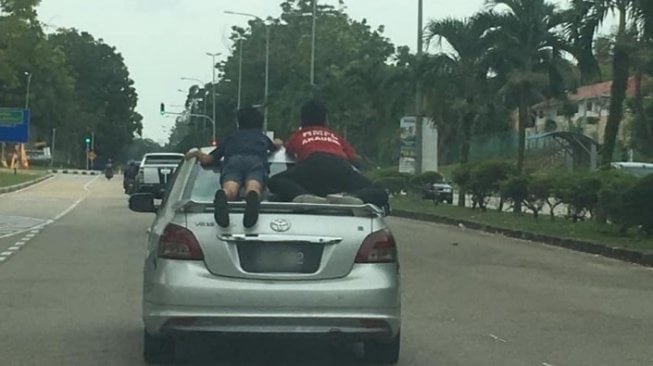 Dua Bocah Duduk di Atap Mobil, Orang Tuanya Ngebut dan Terobos Lampu Merah