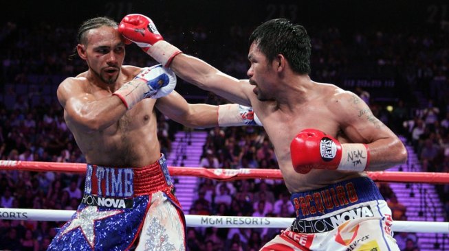 Ikon tinju dunia, Manny Pacquiao (kanan), mendaratkan pukulan telak ke kepala lawannya, Keith Thurman, di MGM Grand Garden Arena, Las Vegas, AS, Sabtu (20/7/2019). [AFP/John Gurzinski]