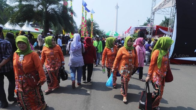 Warga menikmati perayaan Lebaran Betawi ke-12 tahun 2019 di Lapangan Silang Monumen Nasional (Monas), Jakarta, Minggu (21/7). [Suara.com/Muhaimin A Untung]