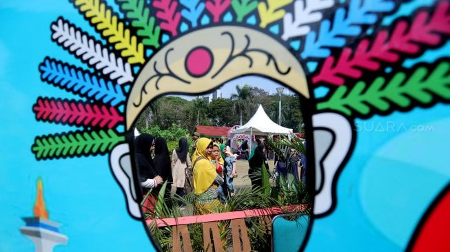 Warga menikmati perayaan Lebaran Betawi ke-12 tahun 2019 di Lapangan Silang Monumen Nasional (Monas), Jakarta, Minggu (21/7). [Suara.com/Muhaimin A Untung]