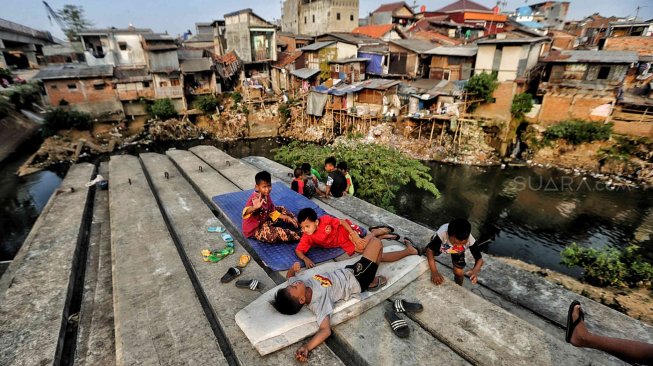 Sejumlah warga beraktivitas di bantaran Sungai Ciliwung, Jakarta, Jumat (19/7). [Suara.com/Muhaimin A Untung]