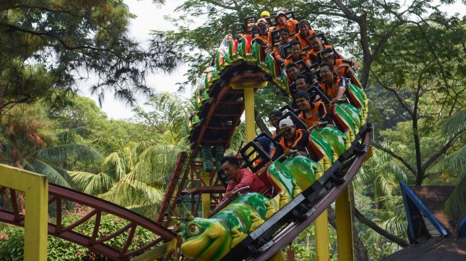 Dua petugas Penanganan Prasarana Sarana Umum (PPSU) DKI Jakarta mencoba wahana permainan saat berwisata di Dufan, Ancol, Jakarta, Senin (22/7). ANTARA FOTO/Wahyu Putro A