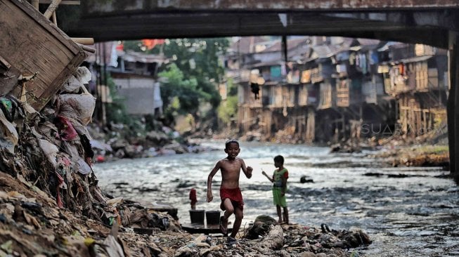 Sejumlah warga beraktivitas di bantaran Sungai Ciliwung, Jakarta, Jumat (19/7). [Suara.com/Muhaimin A Untung]