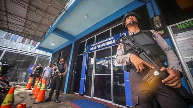 Anggota Polisi Polres Tanjungpinang berjaga di depan kantor Dinas Perhubungan Provinsi Kepulauan Riau saat dilakukannya penggeledahan oleh petugas KPK di Tanjungpinang, Kepulauan Riau, Selasa (23/7). ANTARA FOTO/Andri Mediansyah