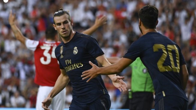 Penyerang Real Madrid, Gareth Bale (kiri) merayakan golnya ke gawang Arsenal bersama sang rekan setim, Marco Asensio, pada laga International Champions Cup 2019 (ICC 2019) di FedExField, Maryland, Amerika Serikat ,Rabu (24/7/2019) pagi WIB. [ANDREW CABALLERO-REYNOLDS / AFP]