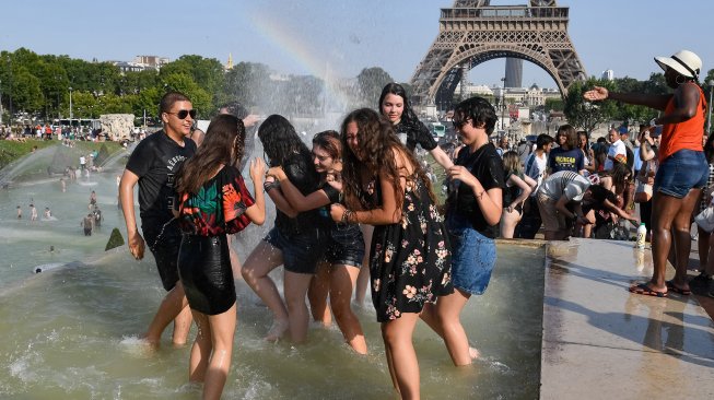 Sekumpulan wraga Paris dan turis berenang di kolam Trocadero Fountains di dekat menara Eiffel, Paris, Perancis, Kamis (25/7). [Bertrand Guay/AFP]