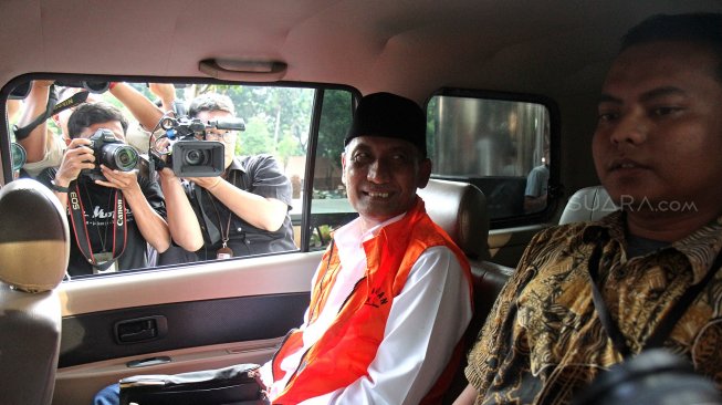 Bupati Kudus Muhammad Tamzil berjalan keluar menggunakan rompi tahanan usai menjalani pemeriksaan di gedung KPK, Jakarta, Sabtu (27/7). [Suara.com/Arief Hermawan P]