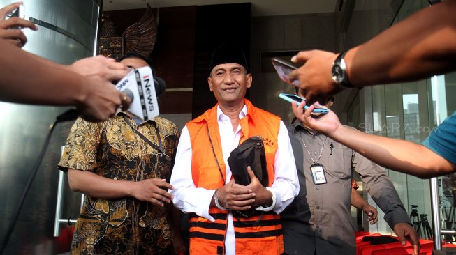 Bupati Kudus Muhammad Tamzil berjalan keluar menggunakan rompi tahanan usai menjalani pemeriksaan di gedung KPK, Jakarta, Sabtu (27/7). [Suara.com/Arief Hermawan P]