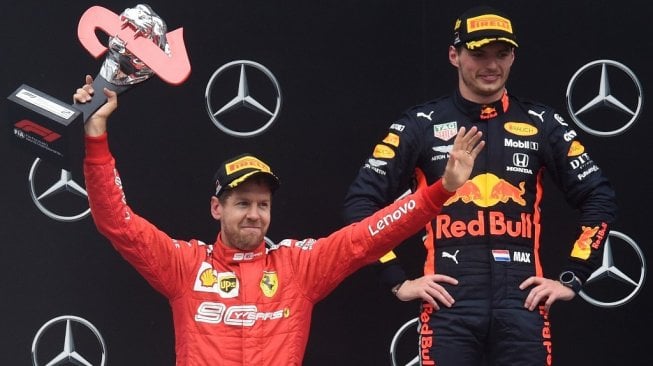 Driver Ferrari, Sebastian Vettel (kiri) berpose di podium Sirkuit Hockenheimring bersama pebalap Red Bull, Max Verstappen usai balapan F1 GP Jerman 2019, Minggu (28/7/2019) malam WIB. [Christof STACHE / AFP]