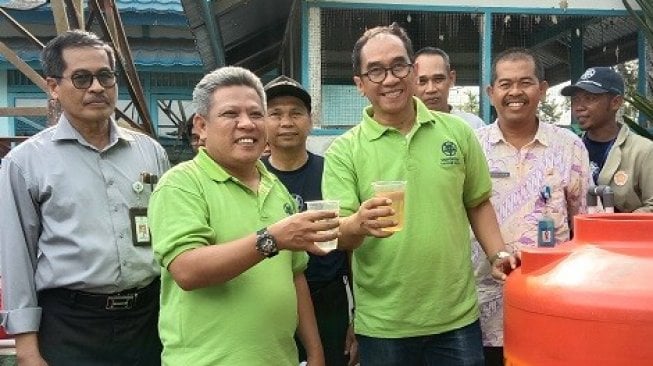 Bupati Kubu Raya, Muda Mahendrawan di dampingi Wakil Rektor Bidang Kerjasama dan Alumni UGM, Paripurna (Kanan) menunjukkan Hasil Pemurnian Air Sungai di Desa Rasau Jaya, Kalimantan Barat (Kalbar). (Suara.com/Rahmat Ali)