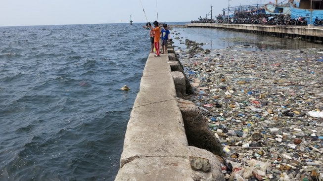 Tumpukan sampah menumpuk di pinggir laut kawasan Pelabuhan Muara Baru, Jakarta Utara, Senin (29/7).  [Suara.com/Oke Atmaja]