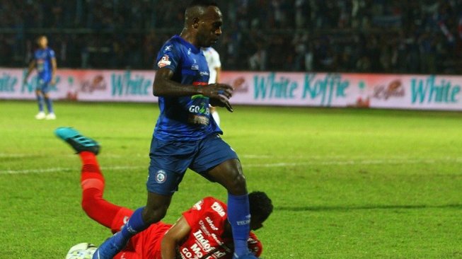 Penjaga gawang Persib Bandung, Muhammad Agil Savik (bawah) berusaha menghalau bola dari kaki pesepakbola Arema FC, Ricky Kayame (kiri) dalam pertandingan Liga 1 2019 di Stadion Kanjuruhan, Malang, Jawa Timur, Selasa (30/7/2019) malam WIB. ANTARA FOTO/Ari Bowo Sucipto]