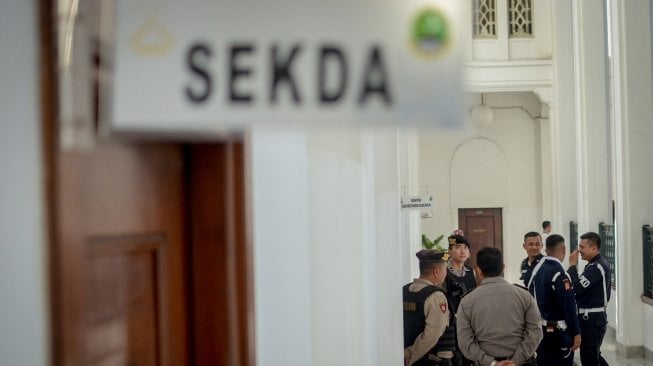 Anggota kepolisian menjaga ruangan Sekda Jabar non aktif Iwa Karniwa saat penggeledahan oleh penyidik KPK di Gedung Sate, Bandung, Jawa Barat, Rabu (31/7). [ANTARA FOTO/Raisan Al Farisi]