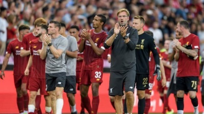 Manajer Liverpool Jurgen Klopp (depan tengah) dan para pemainnya memberikan aplaus kepada suporternya usai mereka mengalahkan Lyon dalam laga uji coba di Jenewa, Swiss. FABRICE COFFRINI / AFP