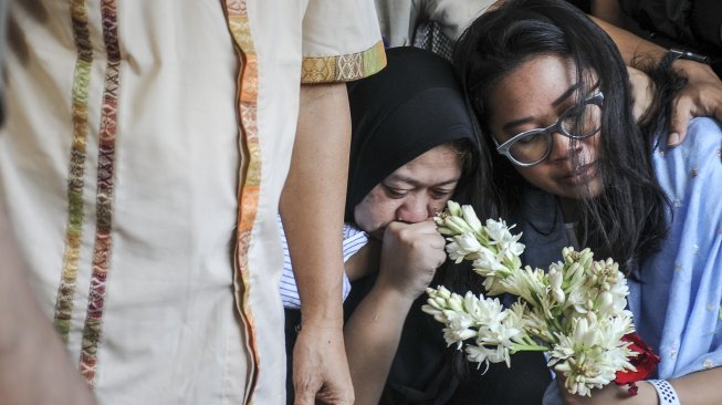 Istri dan anak selebriti almarhum Agung Santoso atau Agung Hercules, Mira Rahayu (kedua kanan) dan Mia Aulia Gaswara (kanan) menangis saat menyaksikan pemakaman di TPU Cikutra, Bandung, Jawa Barat, Jumat (2/8). [ANTARA FOTO/Novrian Arbi]
