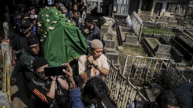 Kerabat membawa foto dan barbel selebriti almarhum Agung Santoso atau Agung Hercules saat akan dimakamkan di TPU Cikutra, Bandung, Jawa Barat, Jumat (2/8). [ANTARA FOTO/Novrian Arbi]