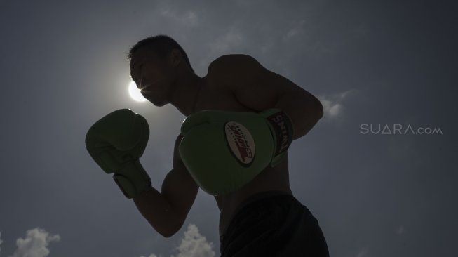 Petinju Indonesia yang juga pemegang gelar WBO Intercontinental kelas ringan (61,2 kilogram),  Daud Yordan menjalani sesi latihan di kawasan pantai Sanur, Bali, Selasa (30/7).  [Foto : Kurniawan Mas'ud untuk suara.com] 
