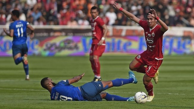 Pesepakbola Persija Jakarta, Ryuji Utomo (kanan) berebut bola dengan pesepakbola Arema FC, Sylvano Comvalius (bawah) dalam pertandingan lanjutan Liga 1 2019 di Stadion Utama Gelora Bung Karno (SUGBK), Jakarta, Sabtu (3/8/2019). [ANTARA FOTO/Aditya Pradana Putra]