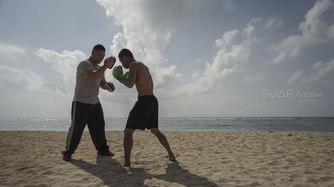 Petinju Indonesia yang juga pemegang gelar WBO Intercontinental kelas ringan (61,2 kilogram),  Daud Yordan menjalani sesi latihan di kawasan pantai Sanur, Bali, Selasa (30/7).  [Foto : Kurniawan Mas'ud untuk suara.com] 