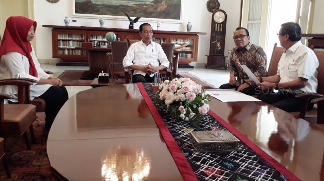 Presiden Joko Widodo didampingi Mensesneg Pratikno dan Menteri Hukum dan HAM Yasonna Laoly bertemu dengan mantan terpidana kasus pelanggaran Undang-Undang Informasi dan Transaksi Elektronik (ITE), Baiq Nuril Maknun saat pemberian salinan petikan Keppres Amnesti kepada Baiq Nuril Maknun di Istana Bogor, Jawa Barat, Jumat (2/8). . [Suara.com/Ummy Hadyah Saleh]

