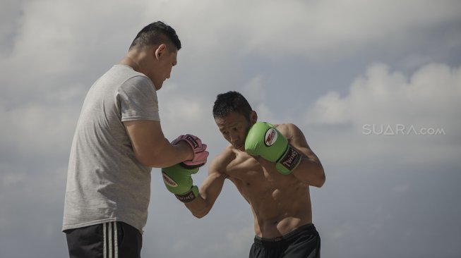 Petinju Indonesia yang juga pemegang gelar WBO Intercontinental kelas ringan (61,2 kilogram), Daud Yordan menjalani sesi latihan di kawasan Pantai Sanur, Bali, Selasa (30/7). [Foto: Kurniawan Mas'ud untuk Suara.com] 