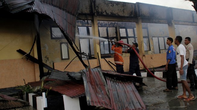 Petugas pemadam kebakaran berusaha memadamkan api yang melahap salah satu ruangan di gedung biro logistik Polda Nusa Tenggara Timur, di Kota Kupang, NTT, Senin (5/8). [ANTARA FOTO/Kornelis Kaha]