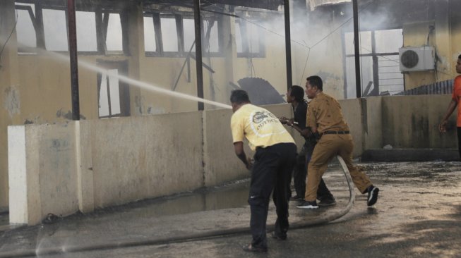 Petugas pemadam kebakaran berusaha memadamkan api yang melahap salah satu ruangan di gedung biro logistik Polda Nusa Tenggara Timur, di Kota Kupang, NTT, Senin (5/8). [ANTARA FOTO/Kornelis Kaha]