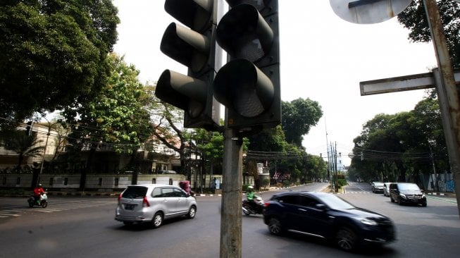 Pengendara melintas di dekat lampu lalu lintas yang tidak berfungsi di Jalan Diponegoro, Jakarta, Senin (5/8). [ANTARA FOTO/Rivan Awal Lingga]