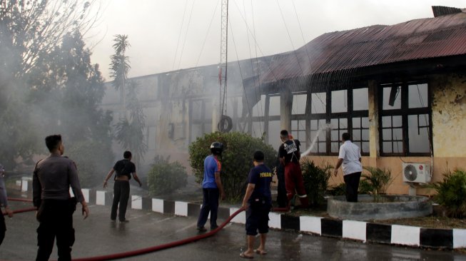 Petugas pemadam kebakaran berusaha memadamkan api yang melahap salah satu ruangan di gedung biro logistik Polda Nusa Tenggara Timur, di Kota Kupang, NTT, Senin (5/8). [ANTARA FOTO/Kornelis Kaha]