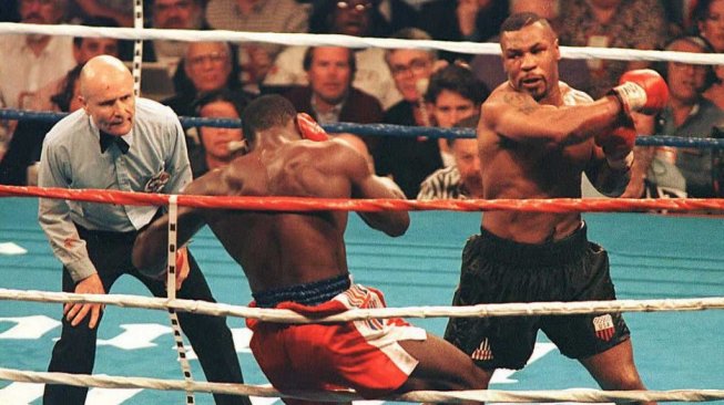Mike Tyson (kanan) memukul KO Frank Bruno (tengah) di ronde ketiga pada pertarungan di MGM Grand Garden Arena, Las Vegas, AS, Sabtu (16/3/1996). [AFP/Mike Nelson]
